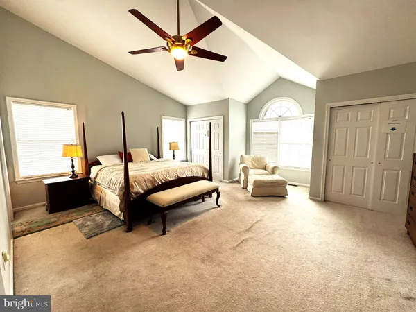 a spacious bedroom with a bed a chandelier and a large window