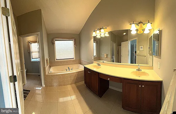 a spacious bathroom with a tub sink shower and mirror