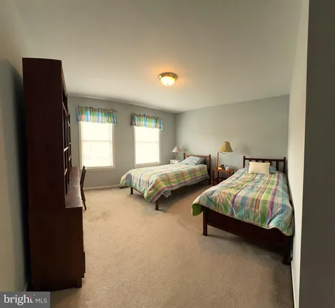 a bedroom with two beds and a window