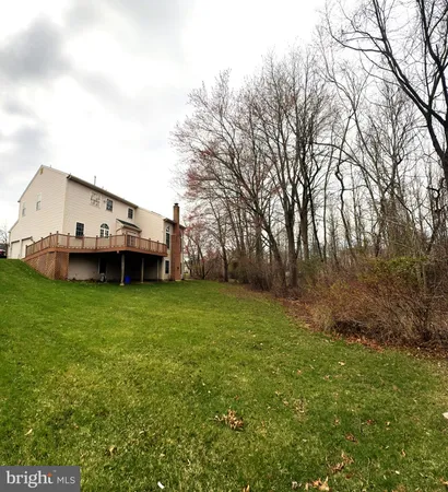 a view of a house with a big yard and large trees