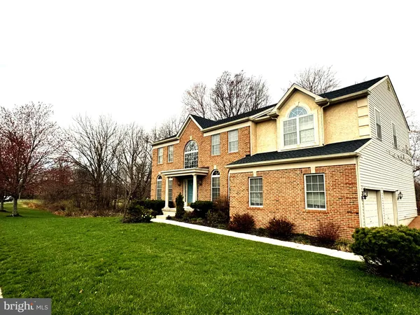 a front view of a house with a yard and trees