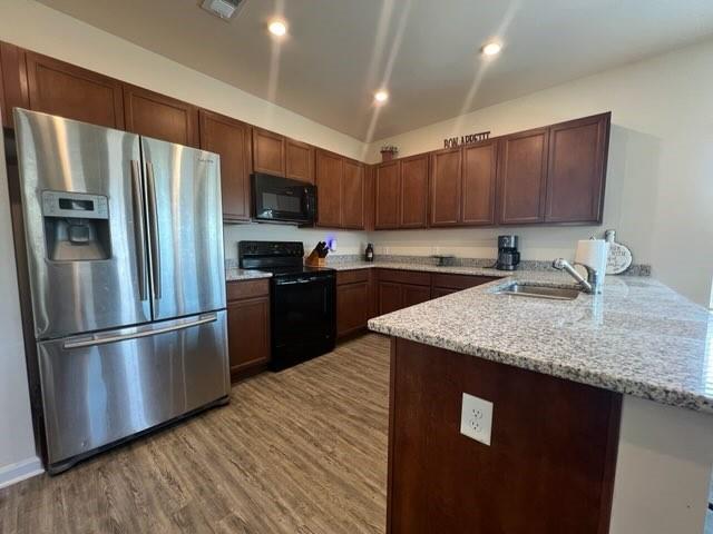 20 Pippin Place Northeast Rome, GA 30165 - Photo 15 of 25 Kitchen with black appliances, light stone countertops, dark wood-type flooring, a peninsula, and recessed lighting