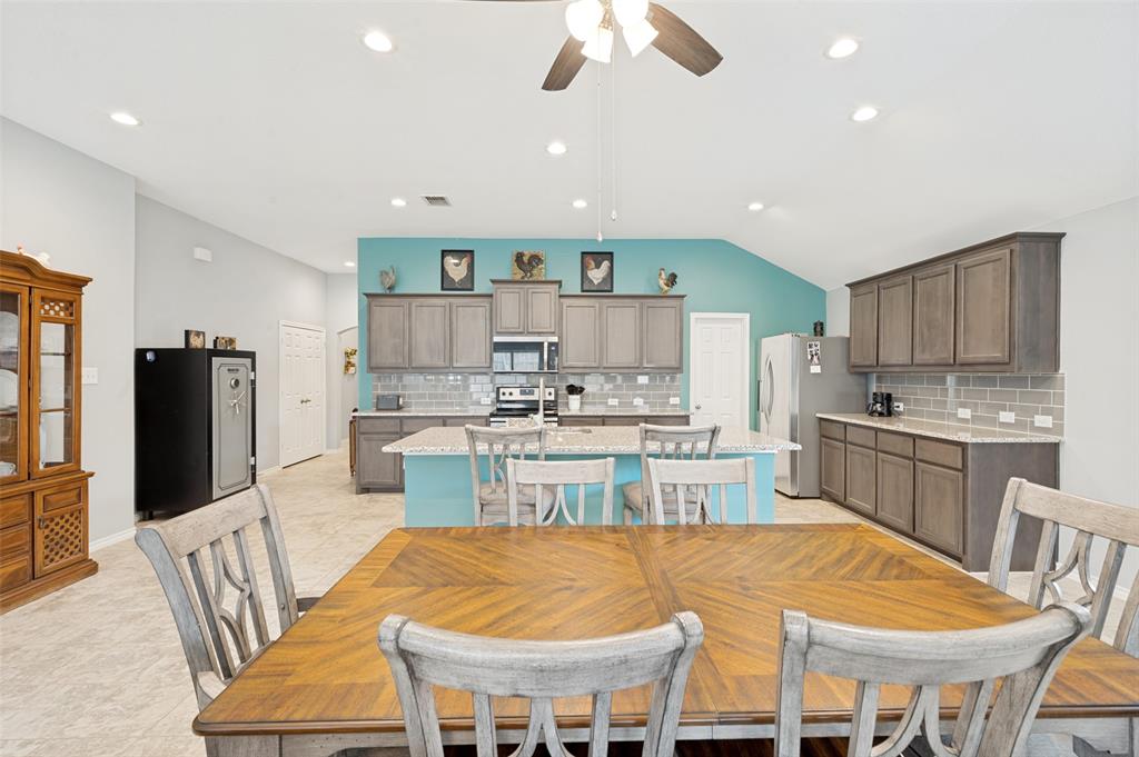 3905 Bridle Path Lane Sanger, TX 76266 - Photo 9 of 26 a kitchen with stainless steel appliances kitchen island granite countertop a kitchen island and chairs in it