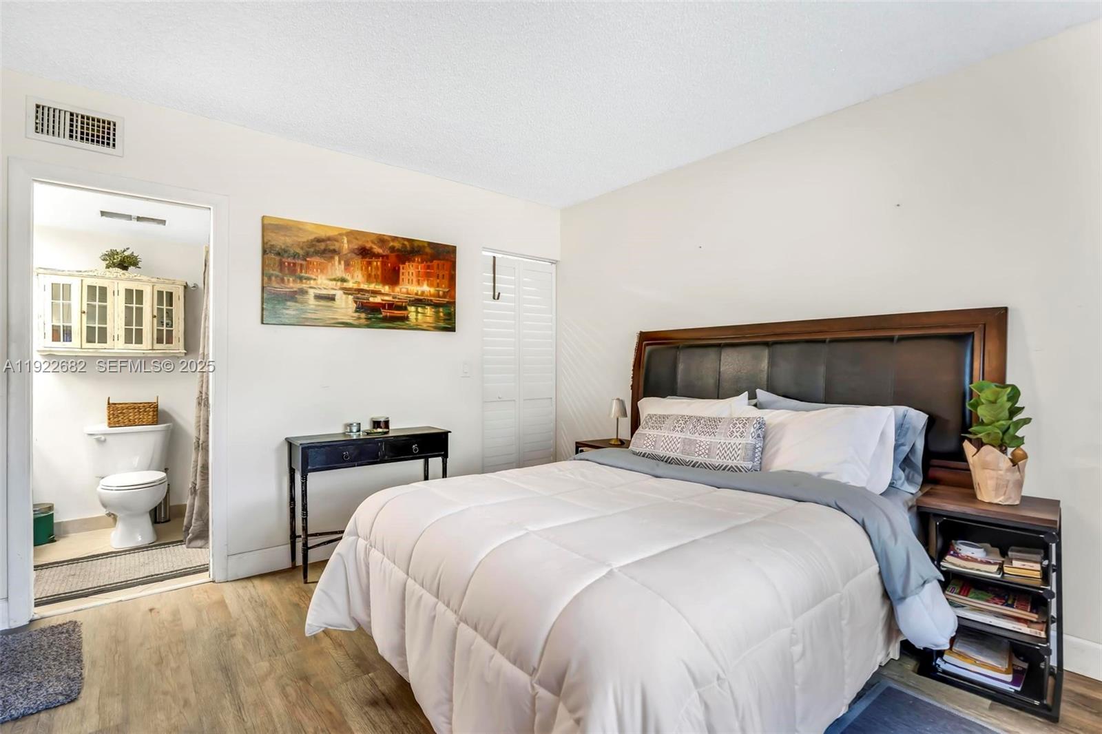 2300 Southwest 22nd Avenue, Unit 109 Delray Beach, FL 33445 - Photo 15 of 49 a bedroom with a bed and wall painting