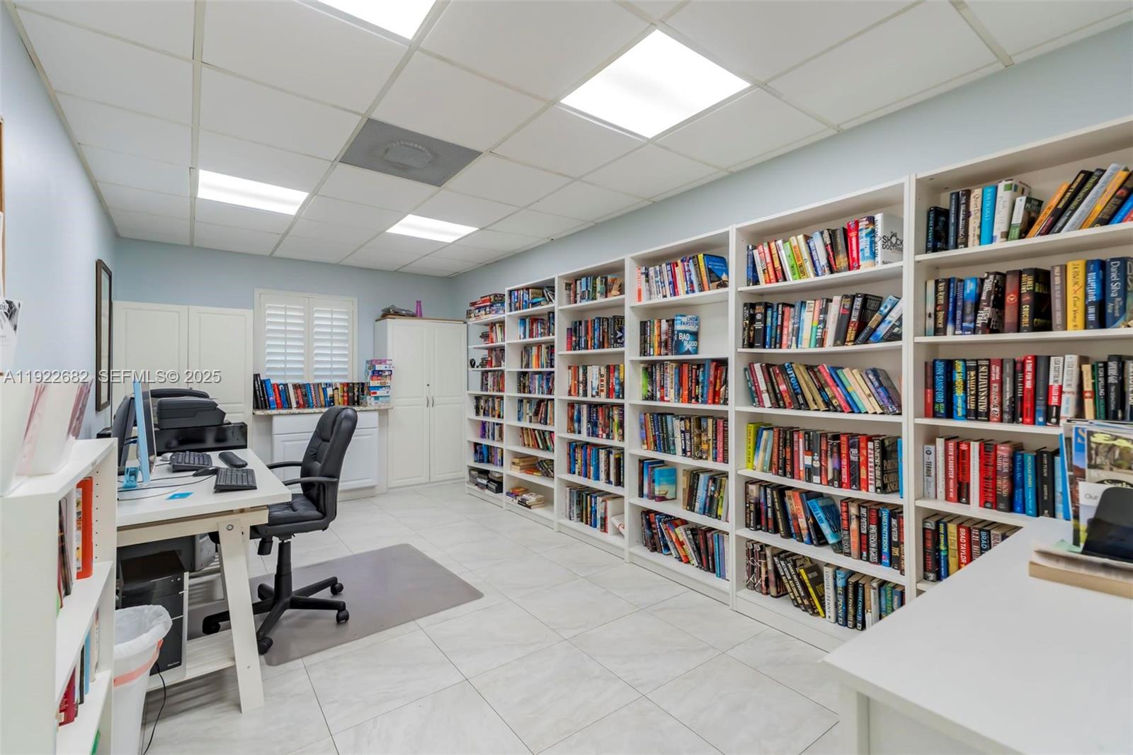 2300 Southwest 22nd Avenue, Unit 109 Delray Beach, FL 33445 - Photo 41 of 49 a view of a workspace with furniture and a bookshelf