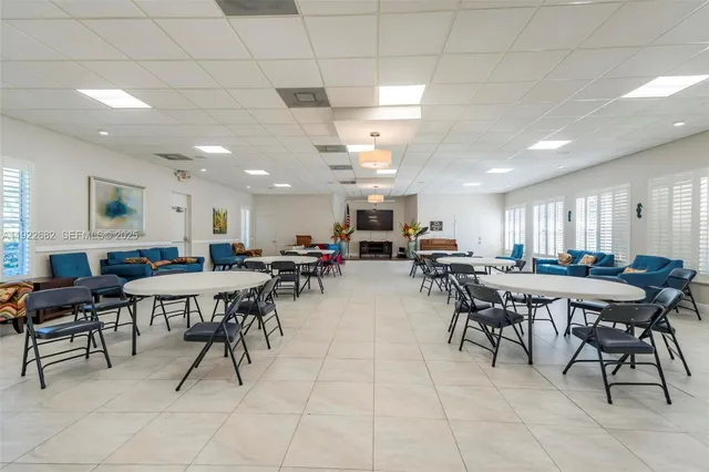 a living room with stainless steel appliances furniture and kitchen view