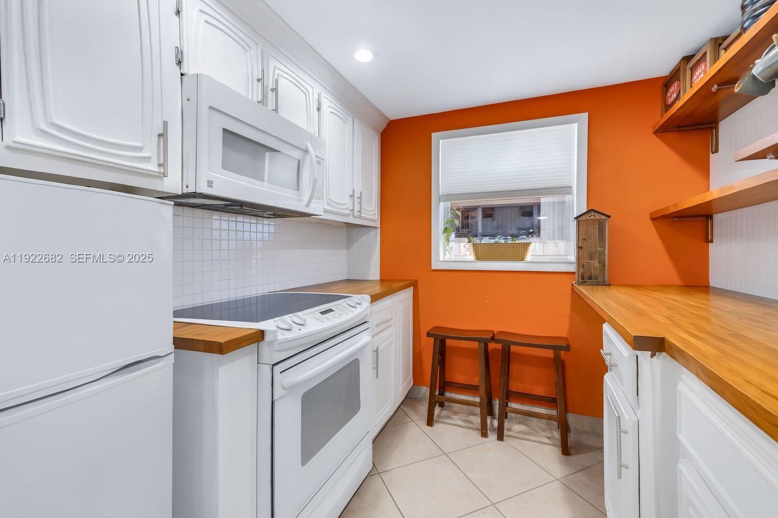 2300 Southwest 22nd Avenue, Unit 109 Delray Beach, FL 33445 - Photo 10 of 49 a kitchen that has a stove and a microwave