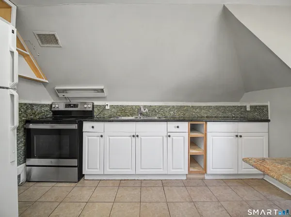 a kitchen with granite countertop a stove and a sink