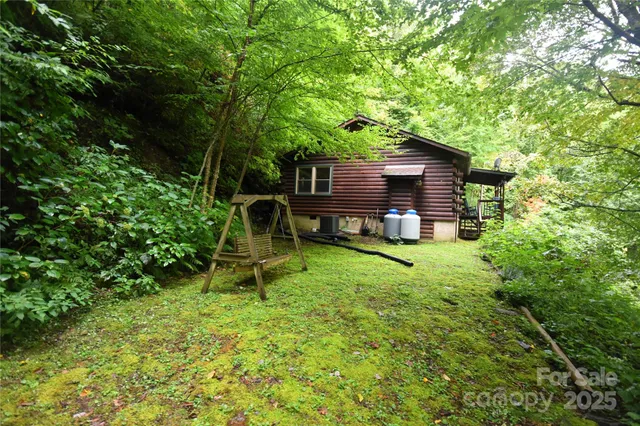 a view of a backyard with wooden fence and a bench