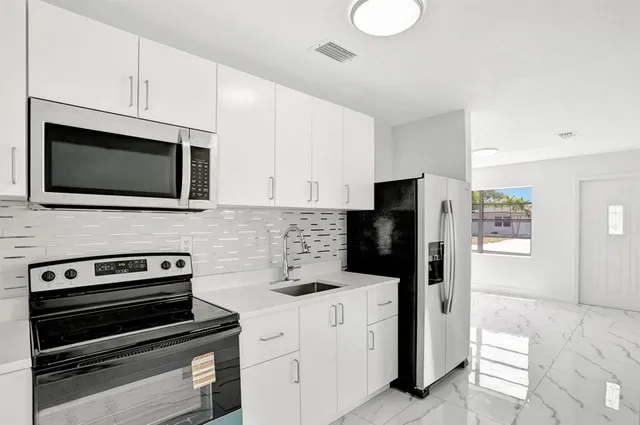 a kitchen with stainless steel appliances a stove microwave and refrigerator