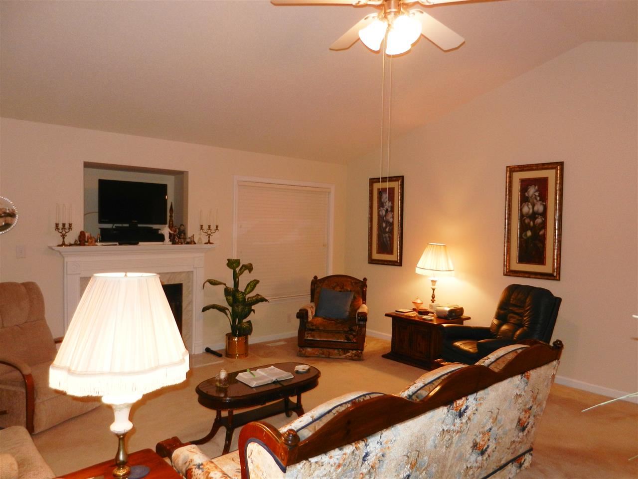 245 Saddle Ridge Drive Willow Spring, NC 27592 - Photo 11 of 24 a living room with furniture a flat screen tv and a window