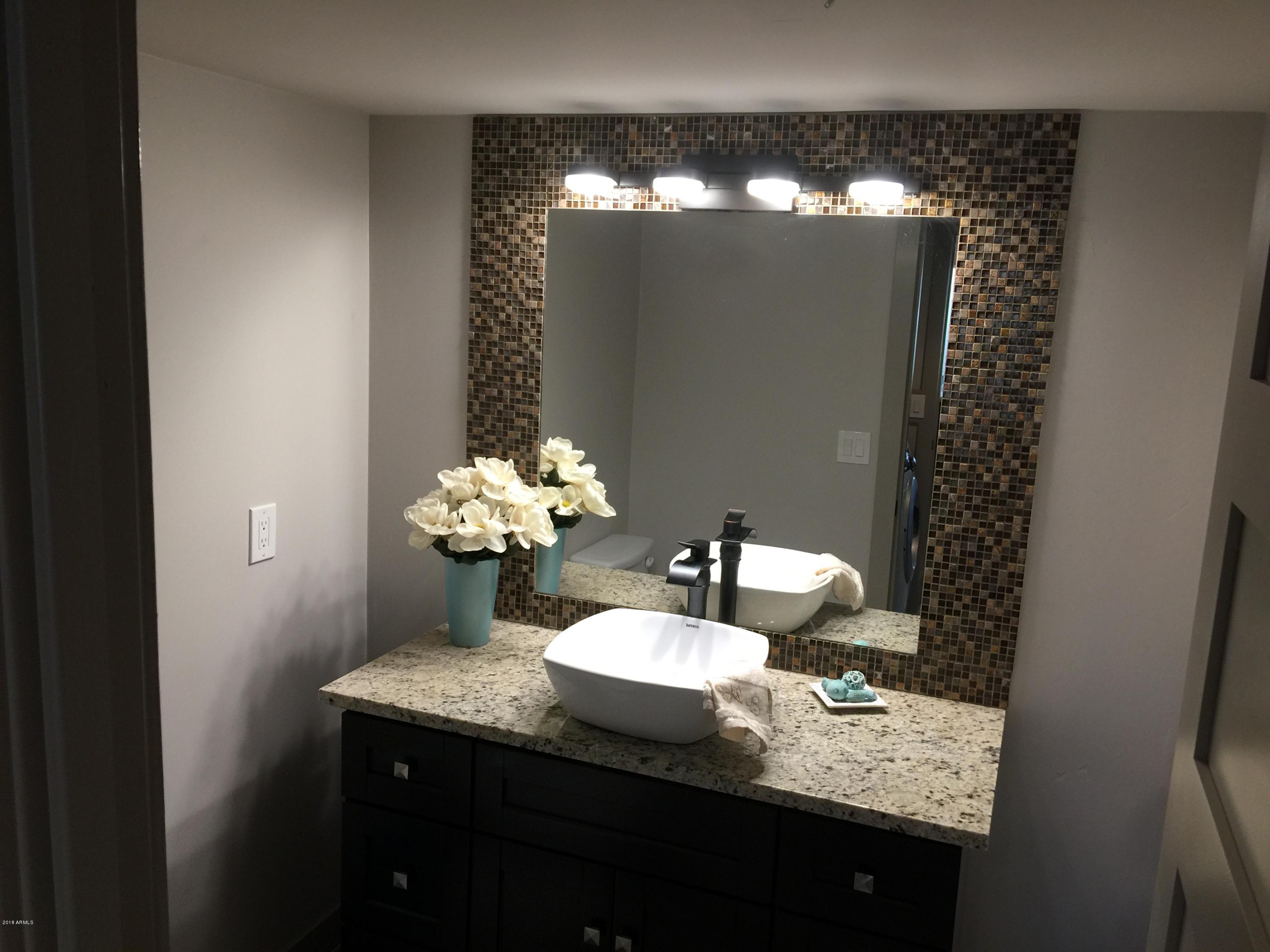 4221 North Miller Road Scottsdale, AZ 85251 - Photo 12 of 20 a bathroom with a granite countertop sink and a mirror