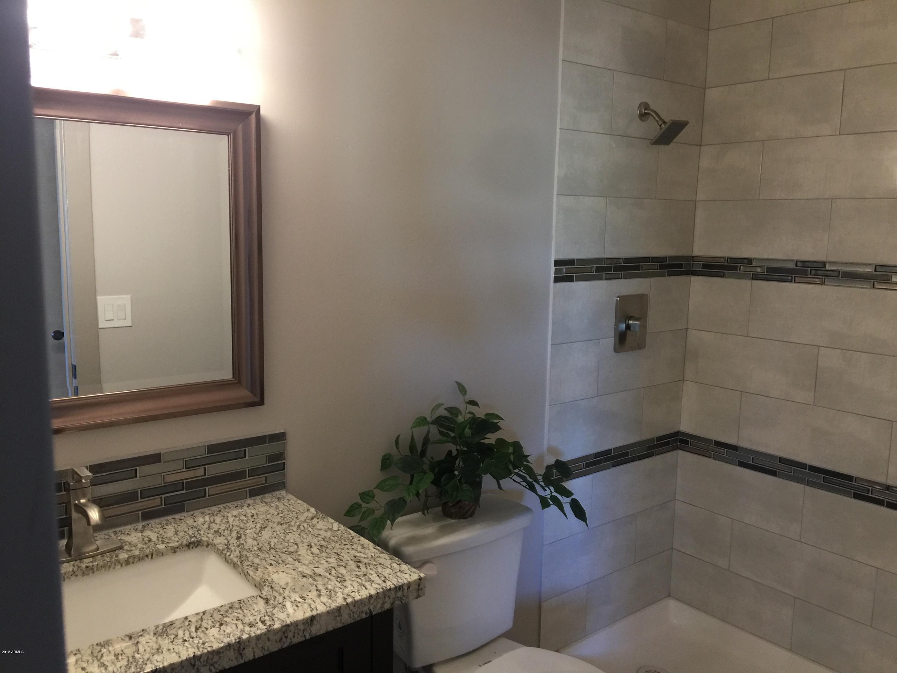 4221 North Miller Road Scottsdale, AZ 85251 - Photo 14 of 20 a bathroom with a granite countertop sink a toilet and shower