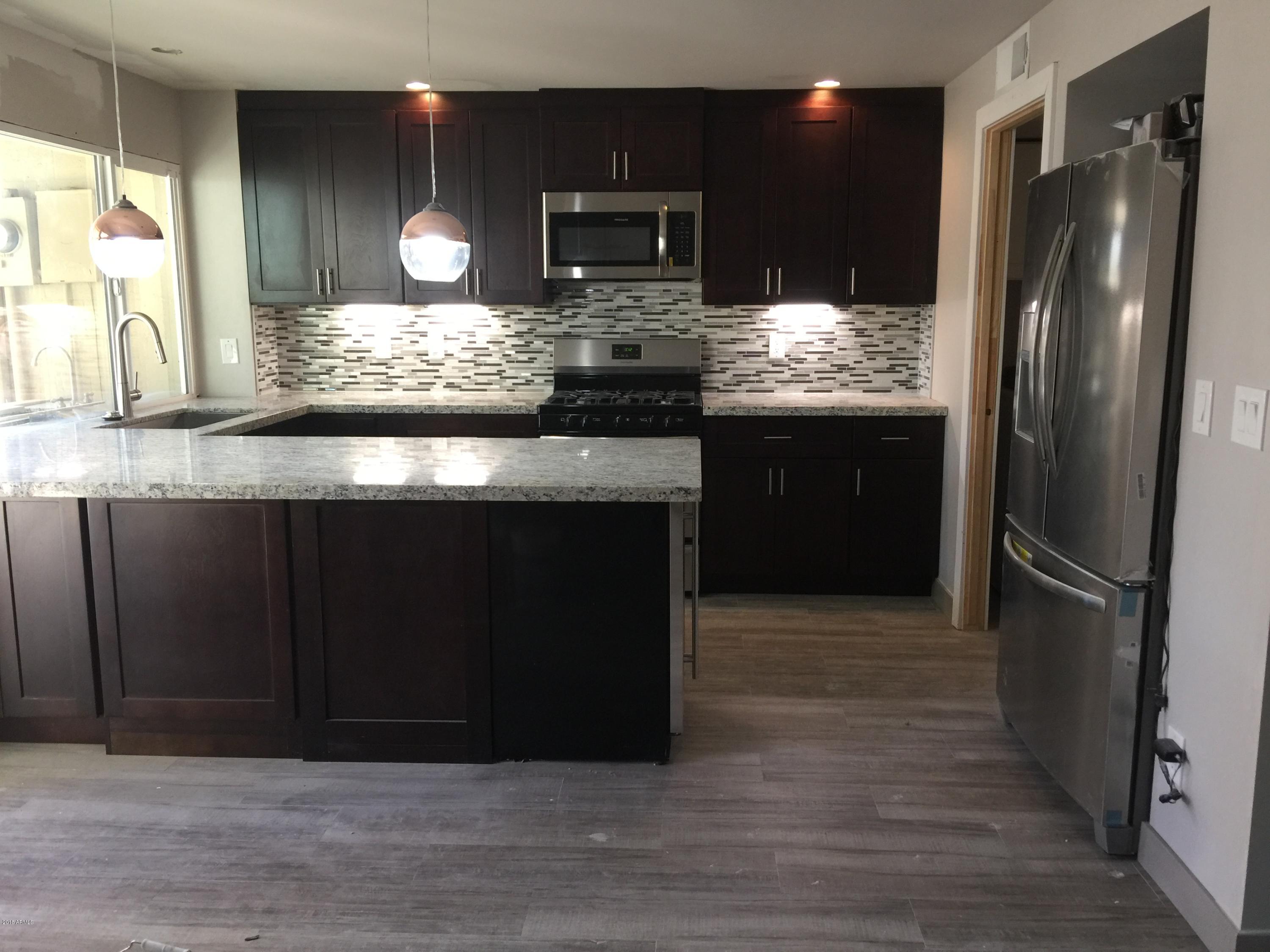 4221 North Miller Road Scottsdale, AZ 85251 - Photo 6 of 20 a kitchen with stainless steel appliances granite countertop a refrigerator and a sink