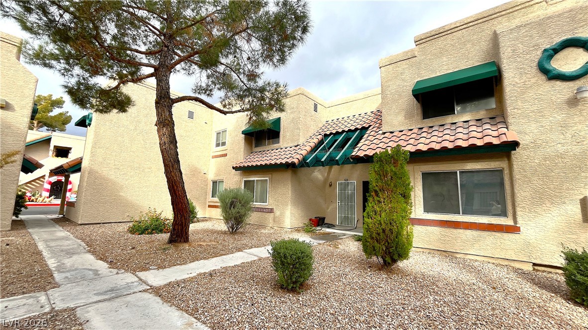 6750 Del Rey Avenue, Unit 123 Las Vegas, NV 89146 - Photo 2 of 21 A desert-friendly landscape surrounds this multi-level home with terracotta roof tiles and vibrant awnings.