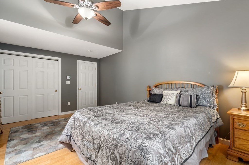 23 Arnold Road Douglas, MA 01516 - Photo 11 of 36 a bedroom with a large bed and a chandelier