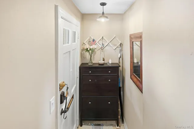 a view of a hallway with a dining table and chandelier