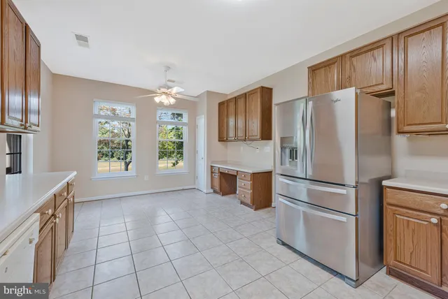 a kitchen with stainless steel appliances a refrigerator a table chairs and a refrigerator