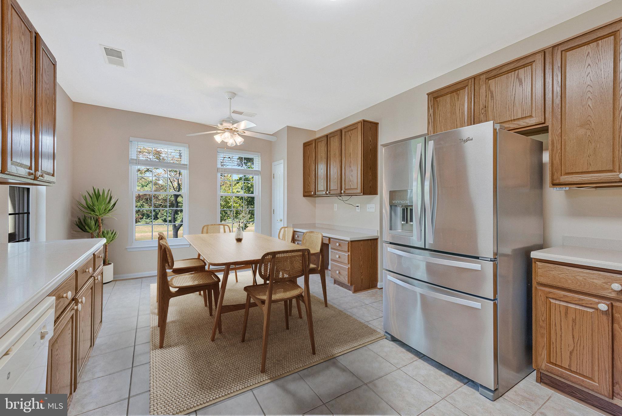 8600 Roaming Ridge Way, Unit 106 Odenton, MD 21113 - Photo 17 of 52 a kitchen with stainless steel appliances a refrigerator a table chairs and a refrigerator