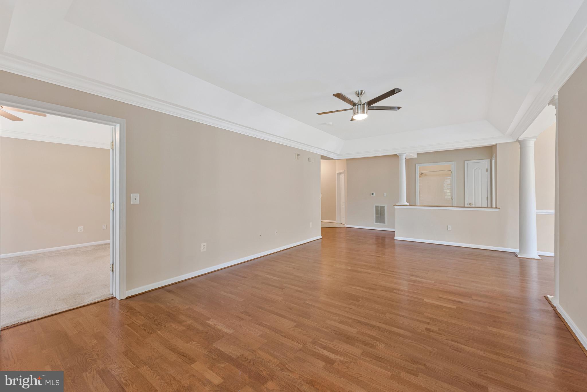8600 Roaming Ridge Way, Unit 106 Odenton, MD 21113 - Photo 5 of 52 an empty room with wooden floor and ceiling fan