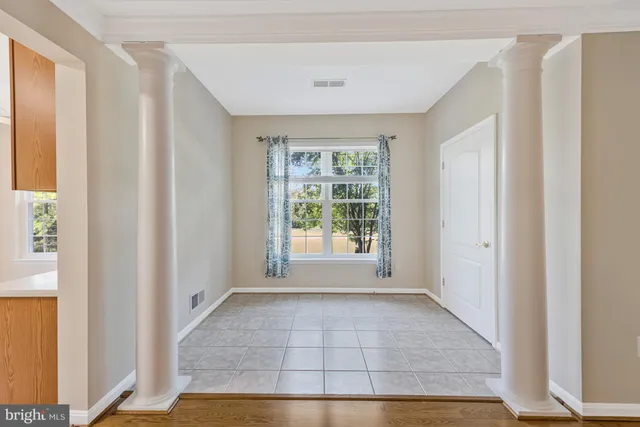 a view of empty room with wooden floor and ceiling fan