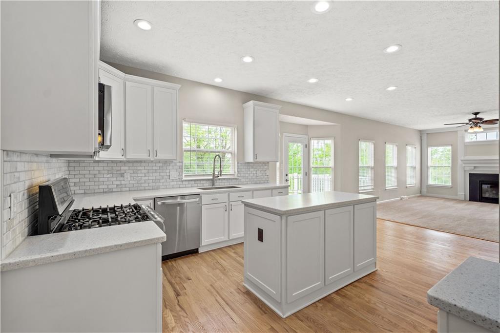543 Hickory Grade Road Bridgeville, PA 15017 - Photo 4 of 32 a kitchen with a sink stove cabinets and wooden floor