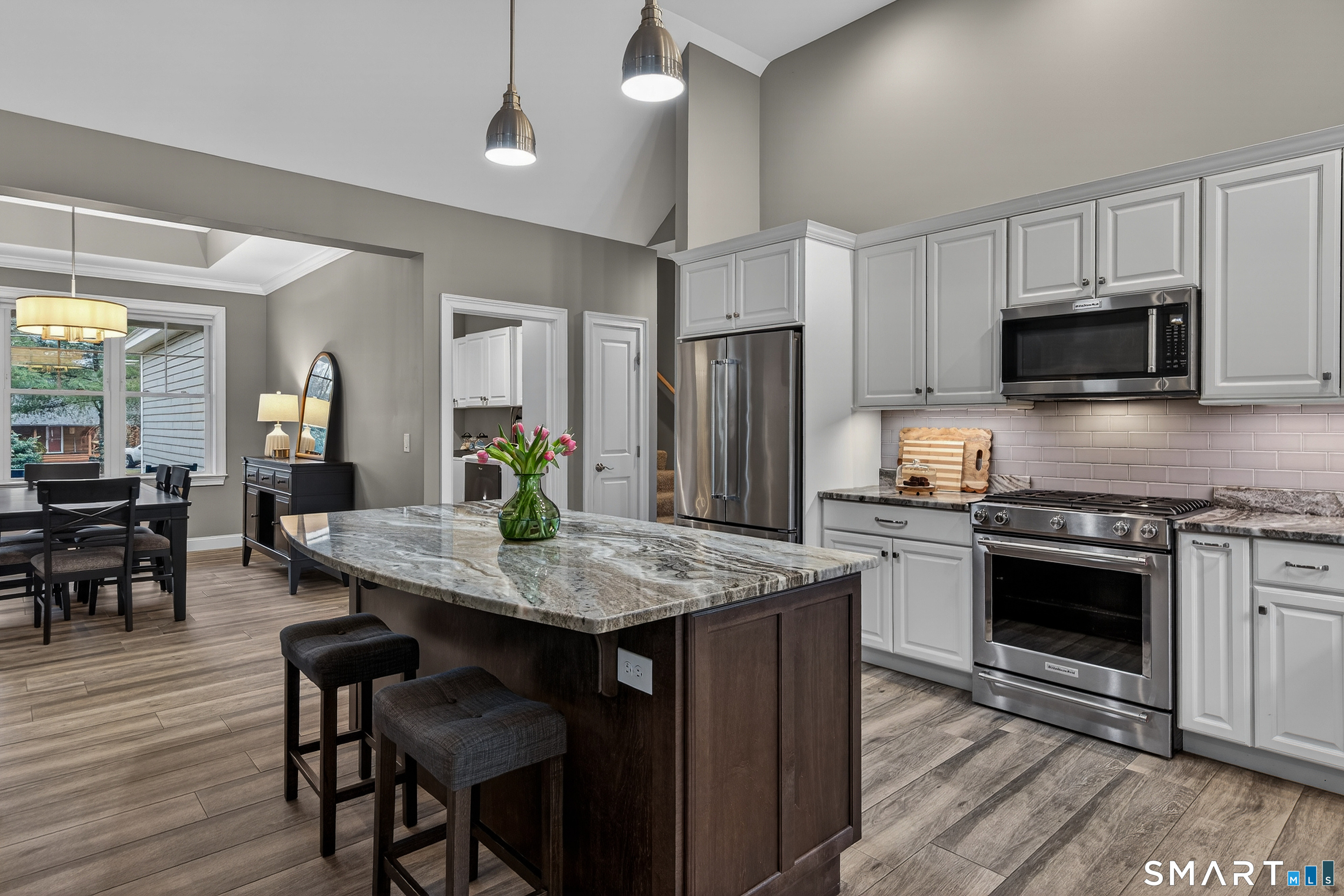 91 Hampden Road Stafford, CT 06076 - Photo 9 of 40 a kitchen with stainless steel appliances granite countertop a stove a refrigerator a kitchen island a sink dishwasher and white cabinets with wooden floor