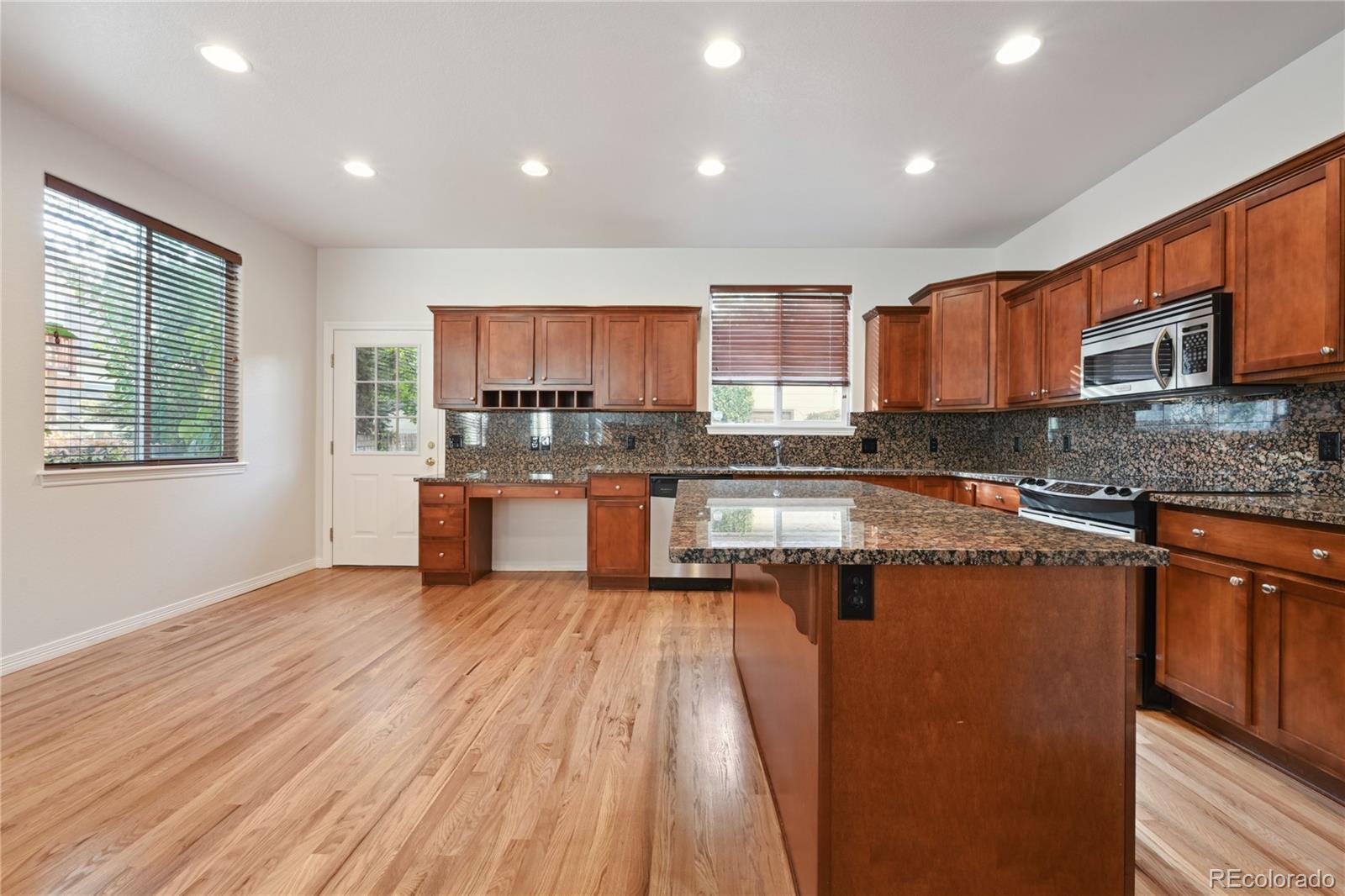 3515 Perry Street Denver, CO 80212 - Photo 12 of 40 a kitchen with stainless steel appliances granite countertop a stove a sink dishwasher and a microwave oven on granite countertops