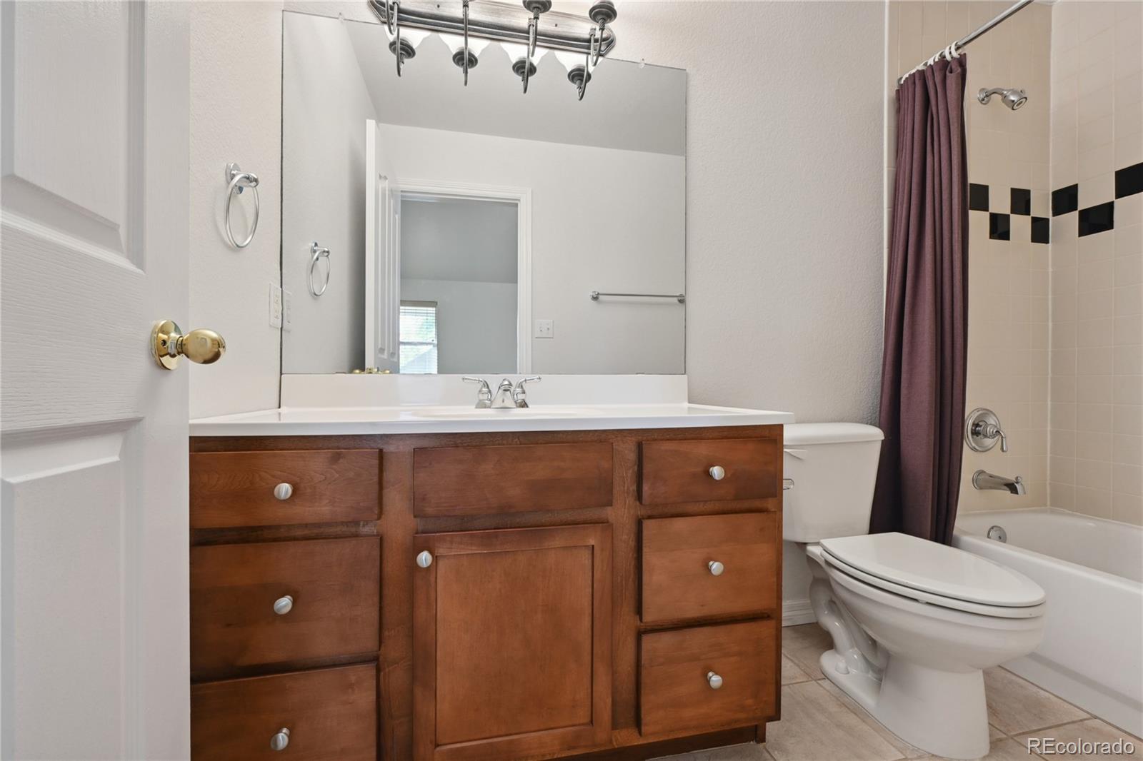 3515 Perry Street Denver, CO 80212 - Photo 23 of 40 a bathroom with a sink a toilet a mirror a vanity and shower