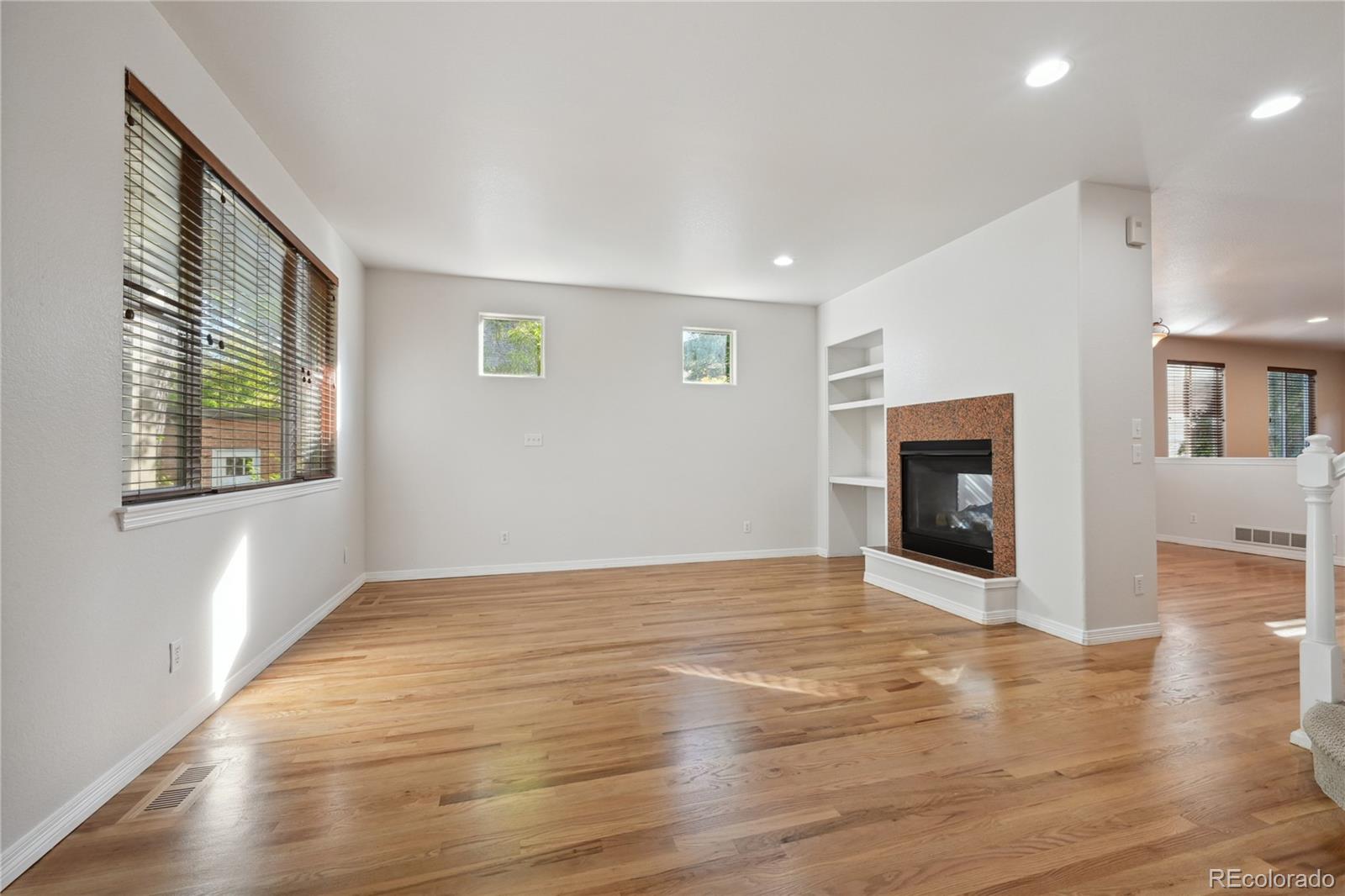 3515 Perry Street Denver, CO 80212 - Photo 6 of 40 an empty room with wooden floor and a fireplace