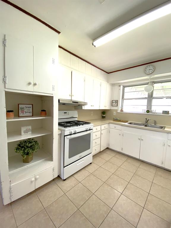 810 Poleman Road Shreveport, LA 71107 - Photo 11 of 25 a white kitchen with stainless steel appliances granite countertop a stove a sink and white cabinets