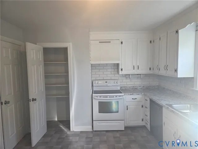 a kitchen with granite countertop a sink cabinets and a wooden floor