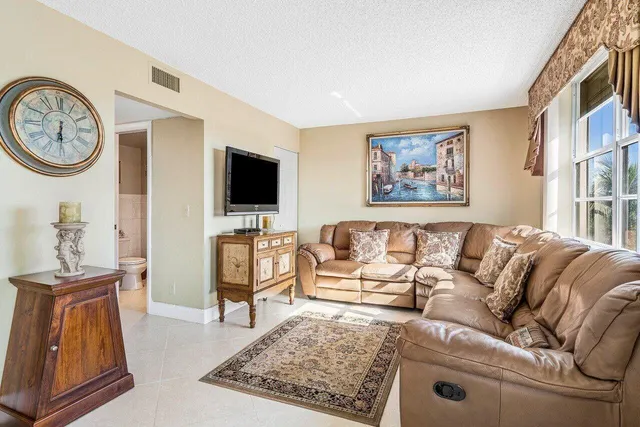 a living room with furniture a clock on the wall and a flat screen tv