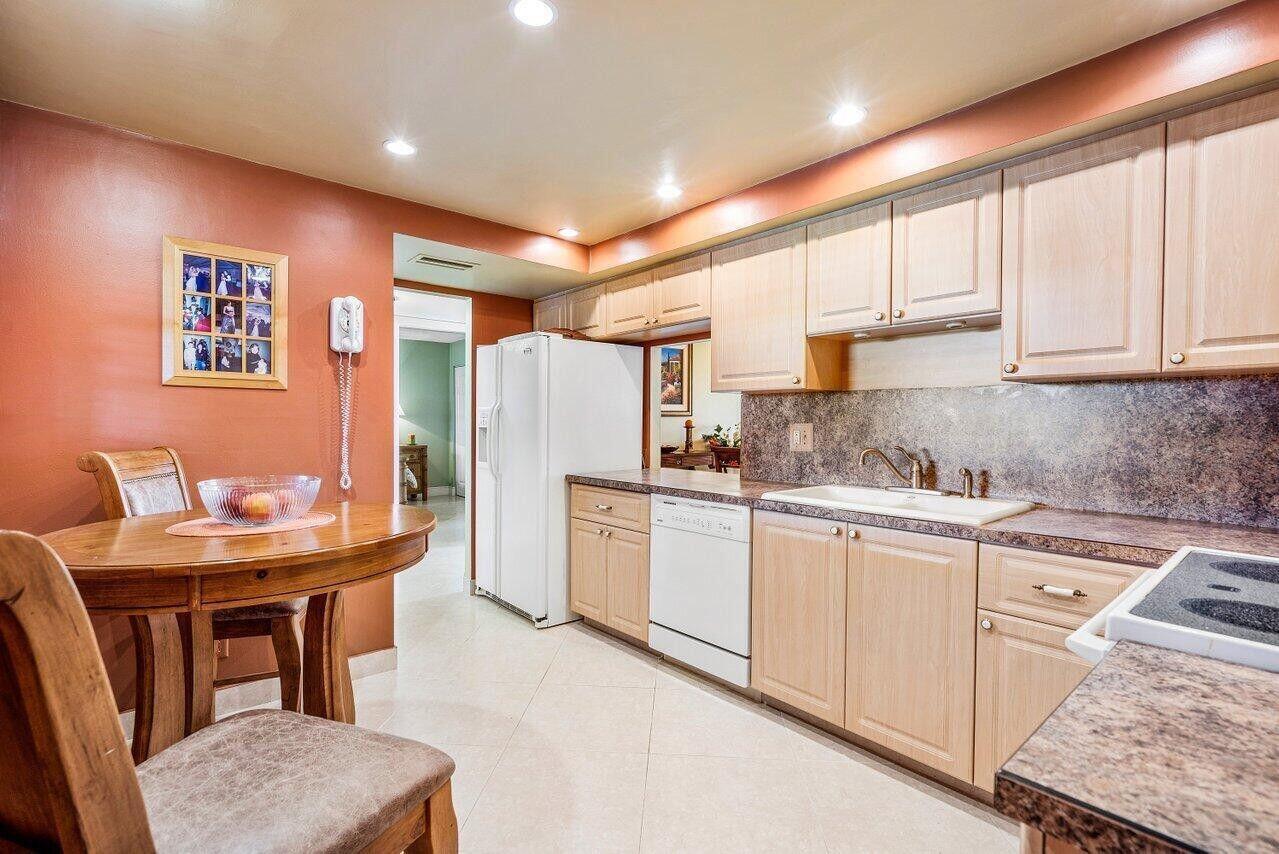 6200 Northwest 2nd Avenue, Unit 415 Boca Raton, FL 33487 - Photo 15 of 31 a kitchen with stainless steel appliances granite countertop a refrigerator a sink dishwasher a stove with white cabinets