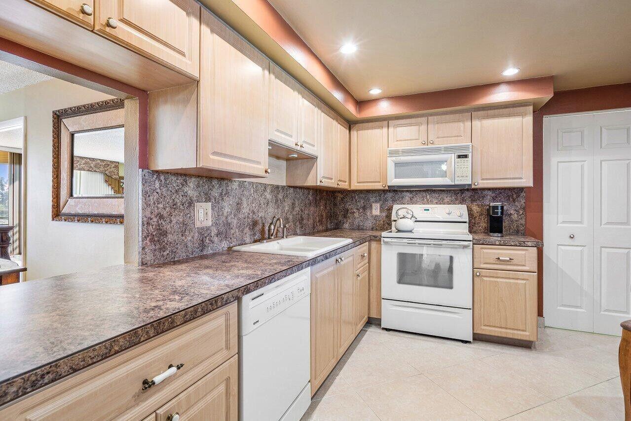 6200 Northwest 2nd Avenue, Unit 415 Boca Raton, FL 33487 - Photo 16 of 31 a kitchen with white cabinets and white appliances