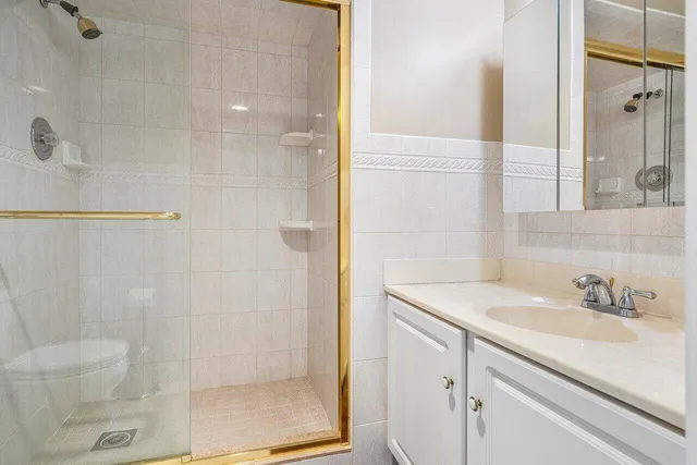 a bathroom with a shower sink and vanity