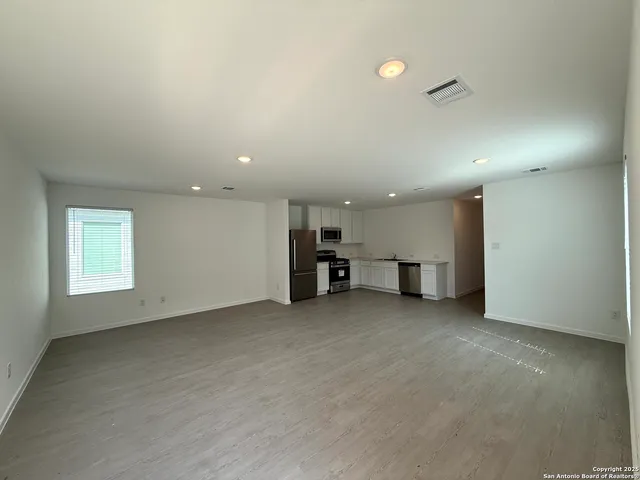 an empty room with furniture and window