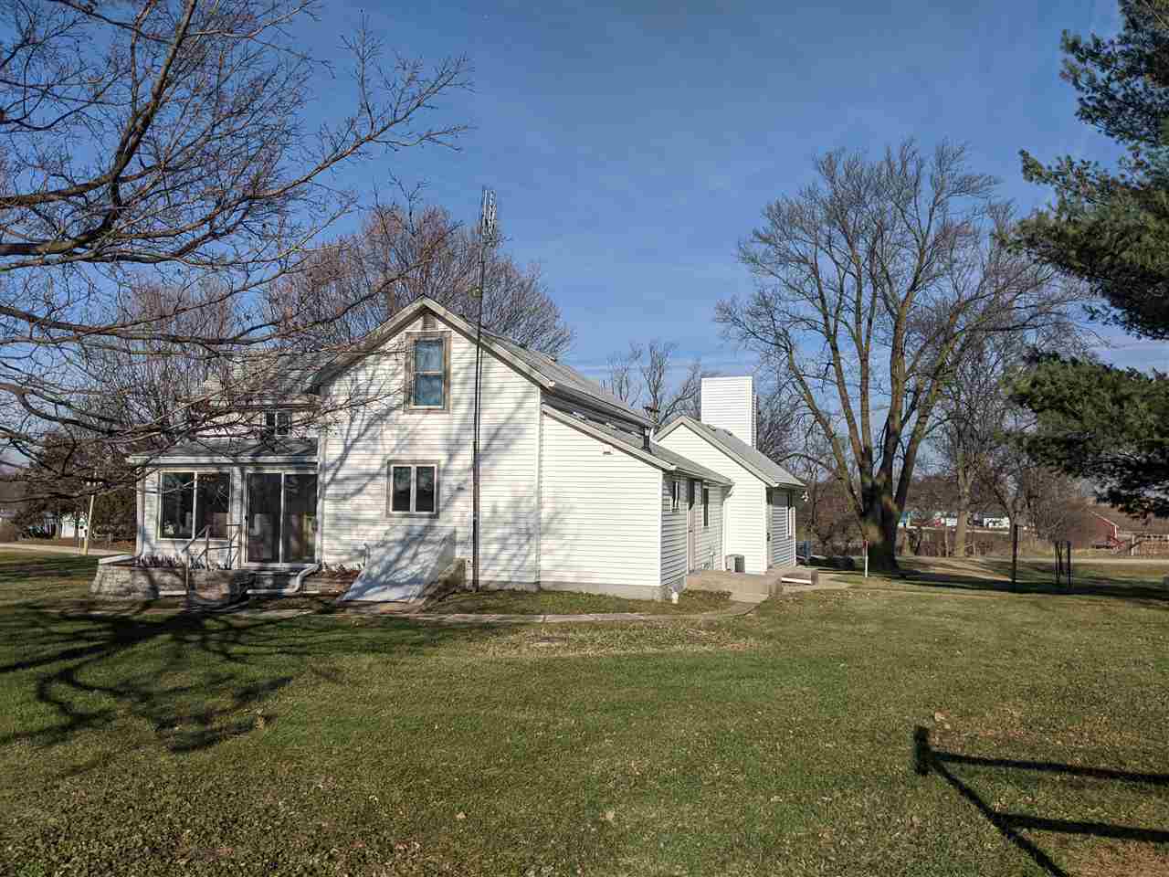 1091 West Buckeye Road Freeport, IL 61032 - Photo 24 of 25 a view of a white house next to a yard with big trees