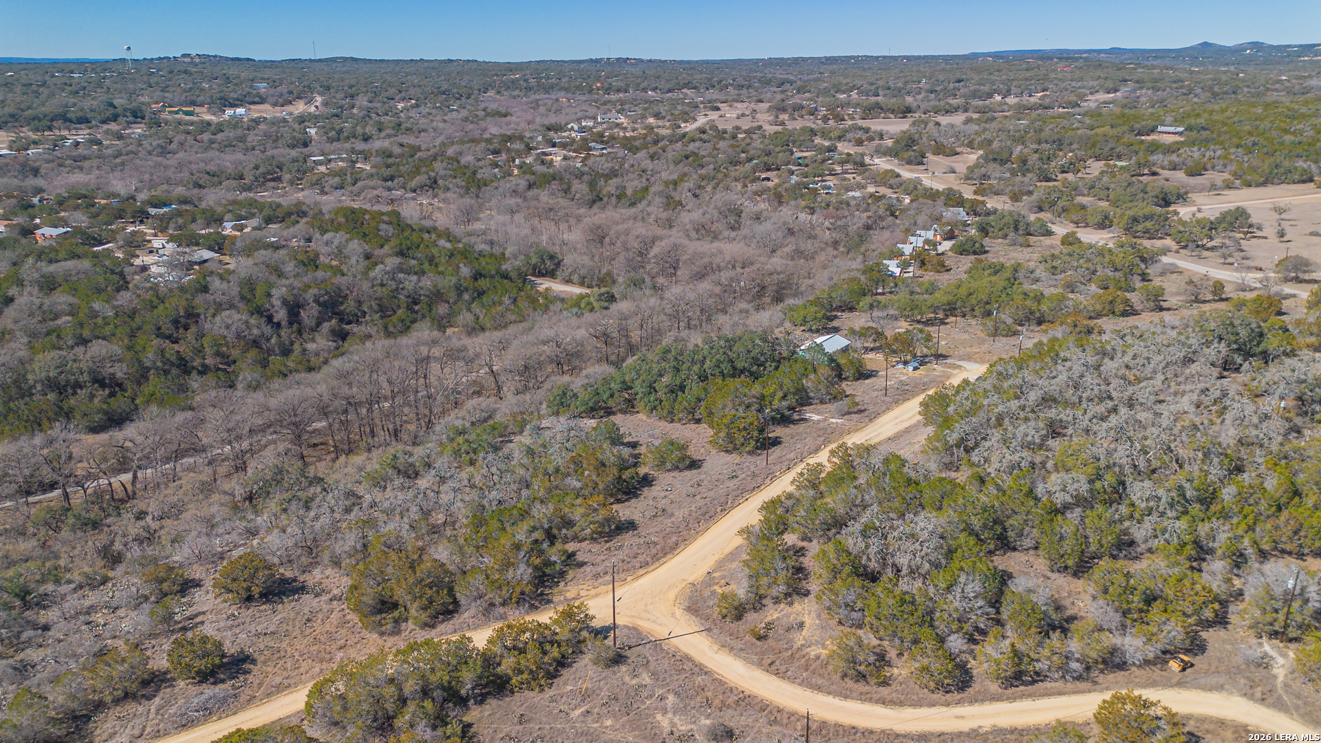 1076 Blue Bonnet Hl Drive Spring Branch, TX 78070 - Photo 34 of 44 a view of a dry yard with trees and houses