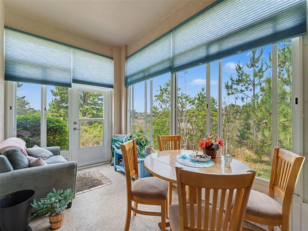 8910 Jericho Road Weeki Wachee, FL 34613 - Photo 45 of 52 a dining room with furniture a flat screen tv and a floor to ceiling window