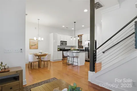 a kitchen with stainless steel appliances refrigerator dining table and chairs