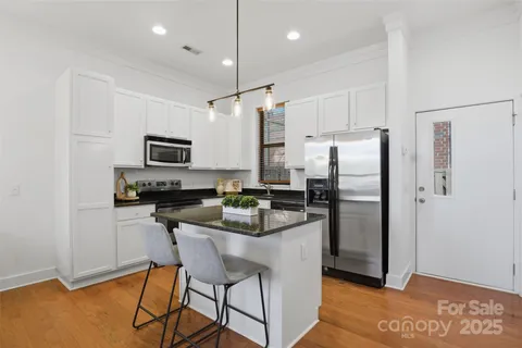 a kitchen with kitchen island a refrigerator stove microwave and cabinets