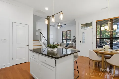 a kitchen with stainless steel appliances kitchen island granite countertop a table chairs and a refrigerator