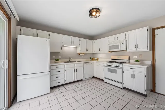 a kitchen with granite countertop cabinets and white appliances