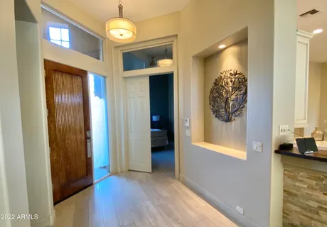 a view of a hallway with wooden floor and a window