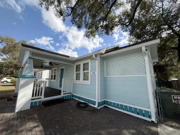 a backyard of a house with barbeque oven and outdoor seating