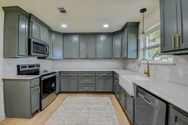 a kitchen with stainless steel appliances granite countertop a sink and stove top oven
