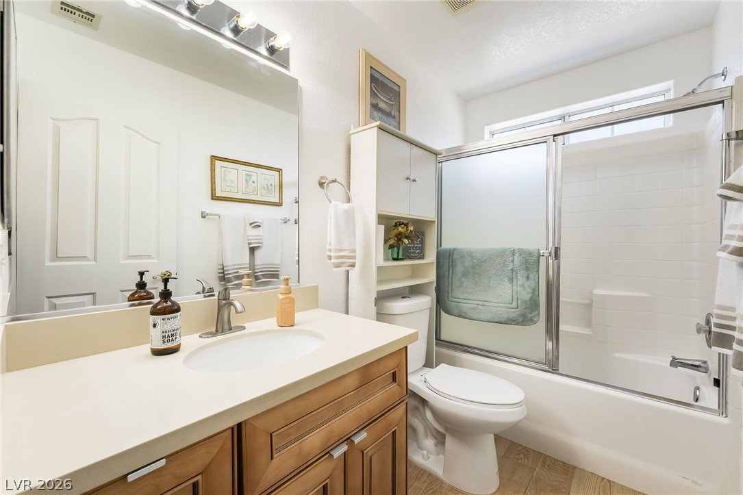 3631 South Blagg Road Pahrump, NV 89048 - Photo 29 of 47 A well-appointed bathroom features a single vanity, a toilet, and a combination tub and shower with sliding glass doors.