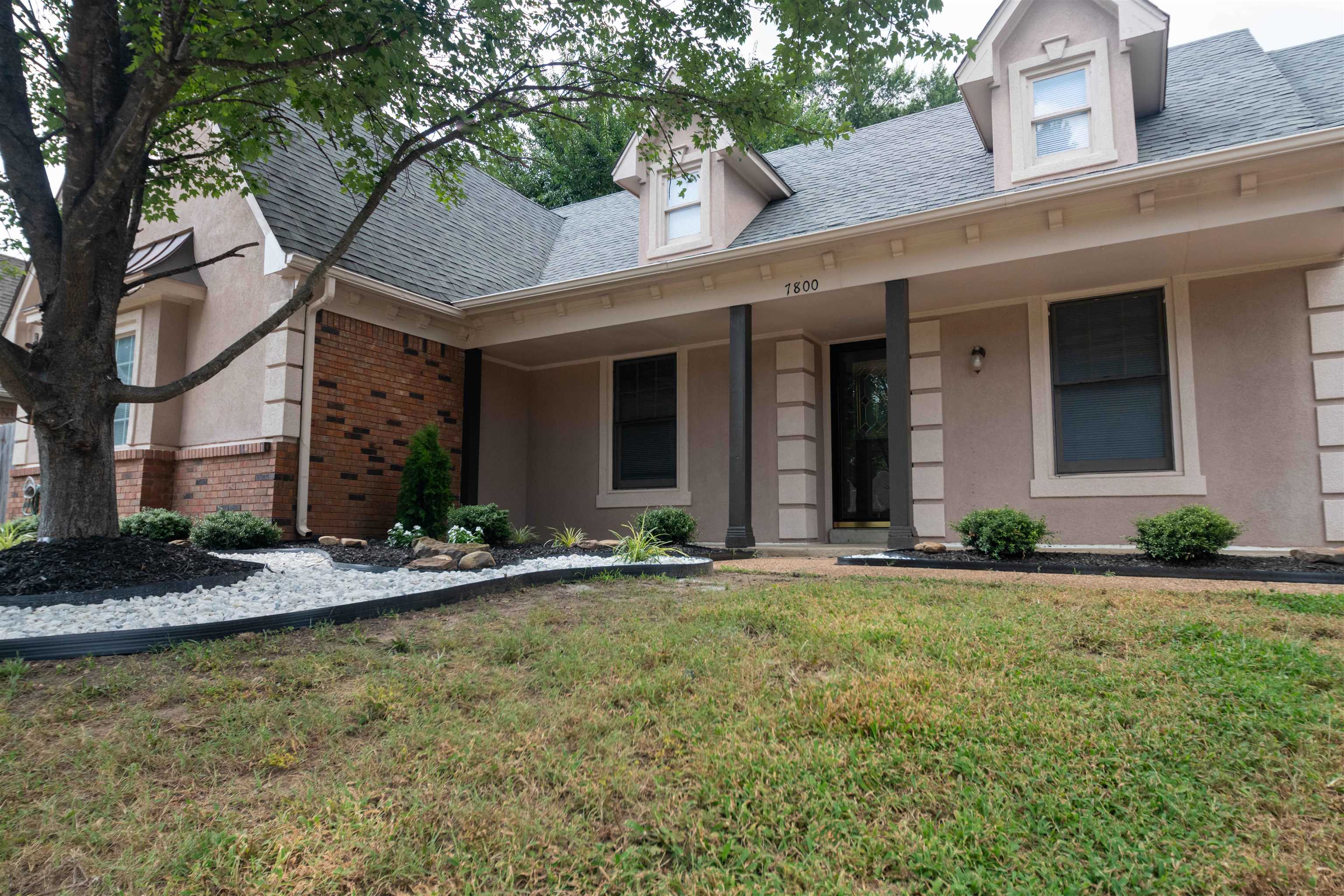 7800 Buck Ridge Cove Memphis, TN 38016 - Photo 6 of 36 Exterior facade featuring a stucco finish with brick accents and a dormer roof
