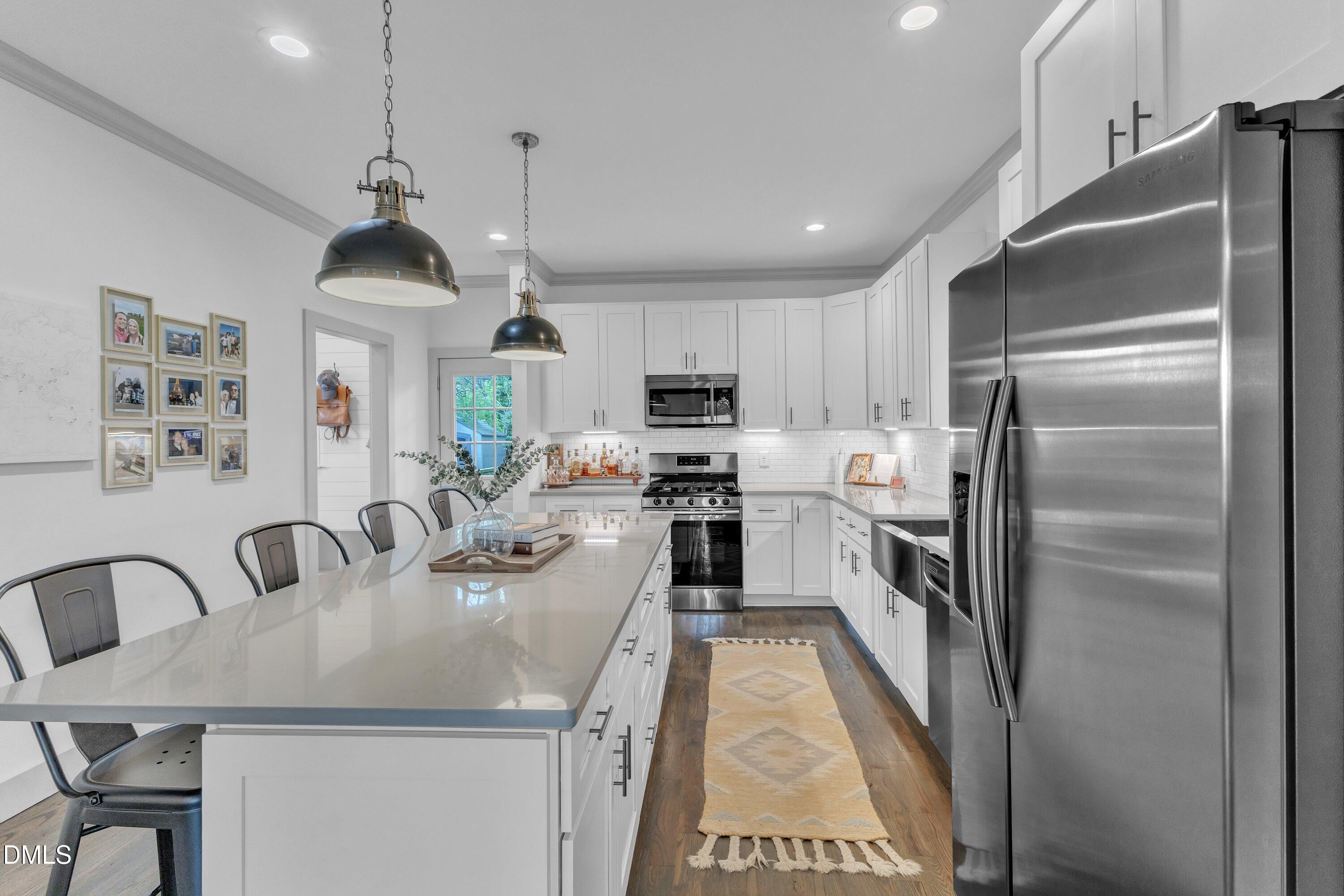 3 Maple Street Raleigh, NC 27610 - Photo 15 of 39 a kitchen with stainless steel appliances granite countertop a refrigerator a sink a stove and a refrigerator with wooden floor